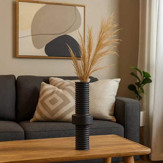 Black ribbed metal vase with matte finish standing on white background showcasing industrial home decor elegance.