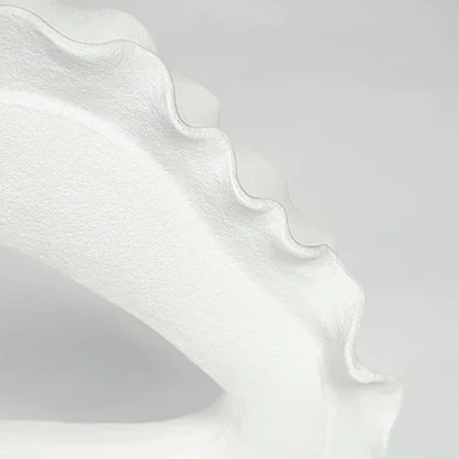 Closeup of white ceramic decorative bowl with scalloped edge showcasing premium craftsmanship and elegant modern styling.