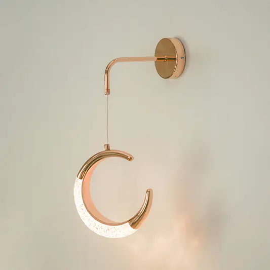 Premium rose gold crescent moon led wall sconce lighting fixture glowing on white background for modern home interior decor.