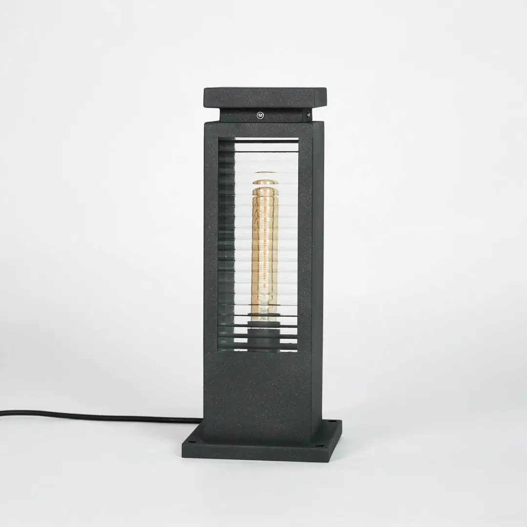 Black metal outdoor pathway light with glass enclosure for modern garden and exterior lighting decor placement.