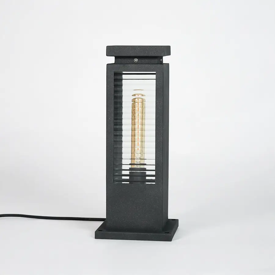 Black metal outdoor pathway light with glass enclosure for modern garden and exterior lighting decor placement.