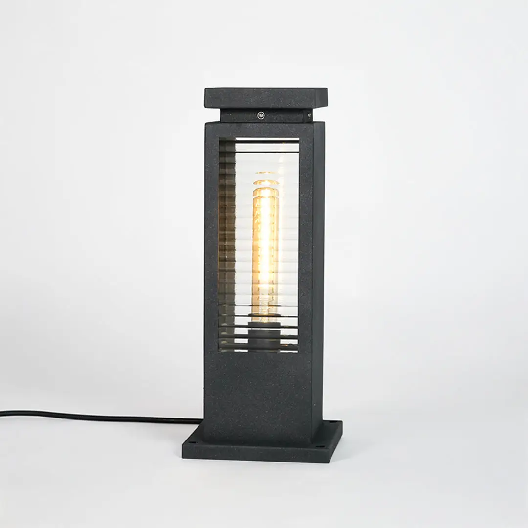 Black metal outdoor bollard light with clear glass panels for modern exterior lighting decor placement styling.