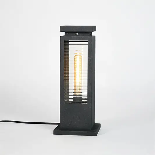 Black metal outdoor bollard light with clear glass panels for modern exterior lighting decor placement styling.
