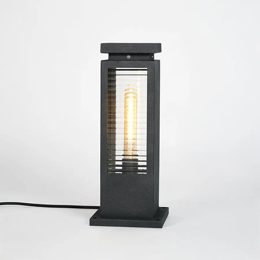 Black metal outdoor bollard light with clear glass panels for modern exterior lighting decor placement styling.