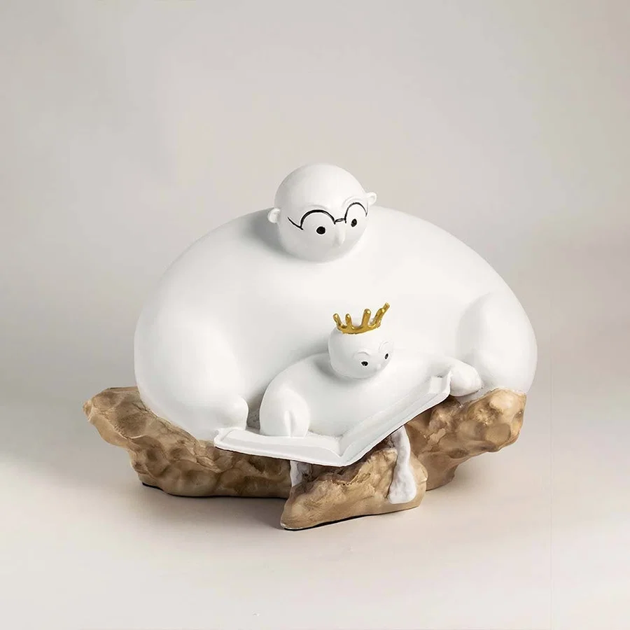 Minimalist parent and child sculpture in white finish with golden crown displayed on plain white background.