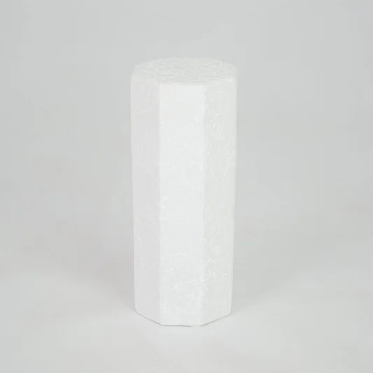 White geometric ceramic vase for modern shelf placement and contemporary indoor home decor styling accent piece.