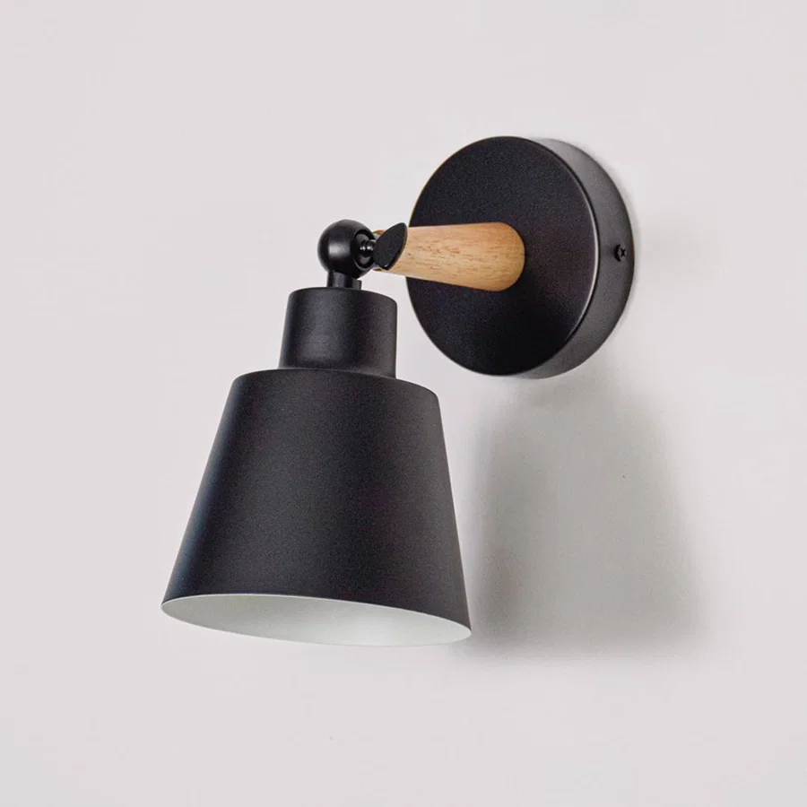 Contemporary wall lamp shown on white background emphasizing smooth metal shade natural wood accent and simple mounting plate for modern interiors.