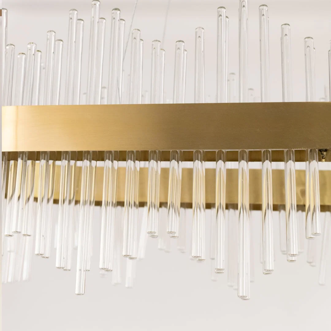 Detailed closeup of gold metal chandelier showing the textured glass rods and gold finish ideal for luxurious modern home decor.