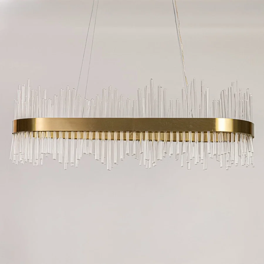 Gold metal chandelier with vertical glass rods displayed with lights off on a white background showing its sleek contemporary structure.