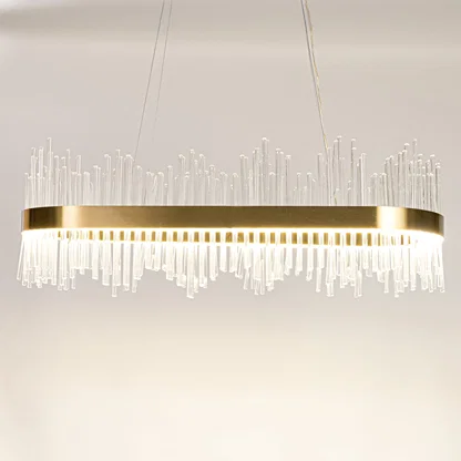 Gold metal chandelier with clear glass rods shown with lights on against a white background highlighting its bright elegant illumination.