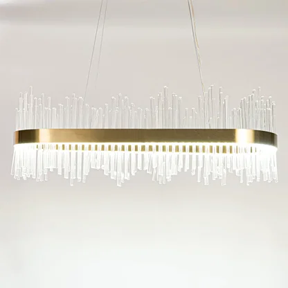 Gold metal chandelier with layered glass rods shown with lights on against a white background emphasizing its warm glowing upscale design.