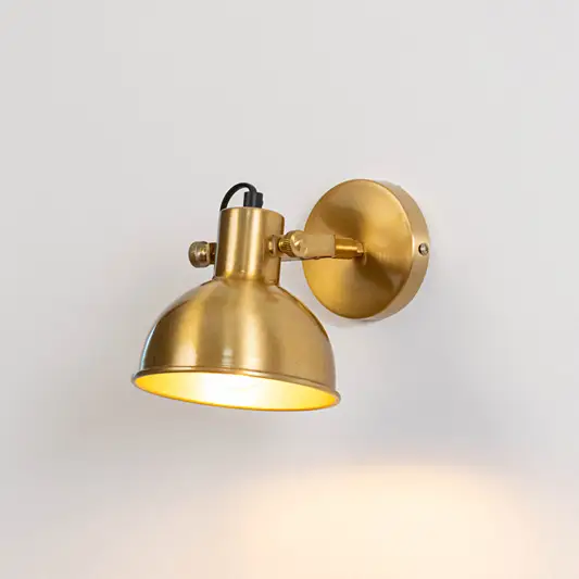 Industrial metal wall light in gold finish with dome shade for indoor or outdoor accent lighting decor placement white background.