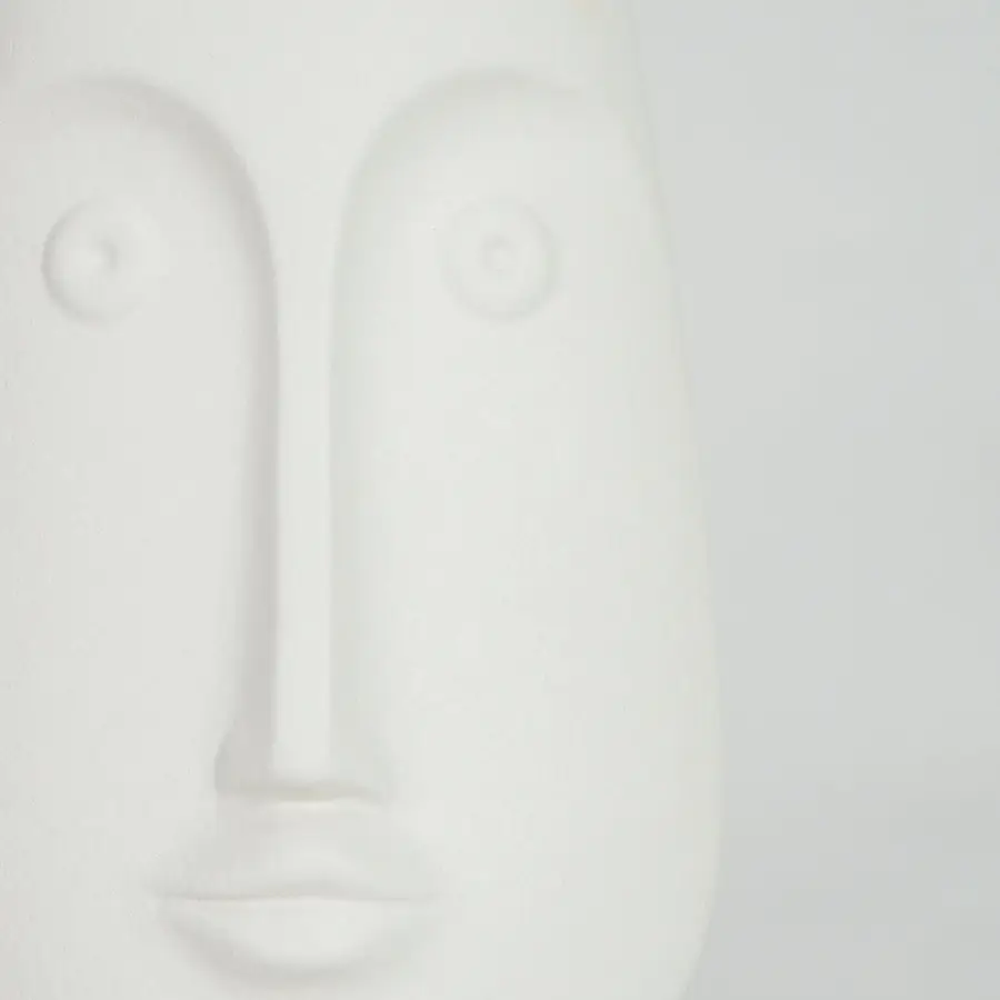 Closeup image of white ceramic abstract face sculpture for modern shelf decor styling with smooth matte finish.