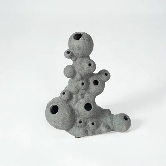 Grey textured ceramic decor object for modern shelf placement and artistic indoor living room styling accent piece.