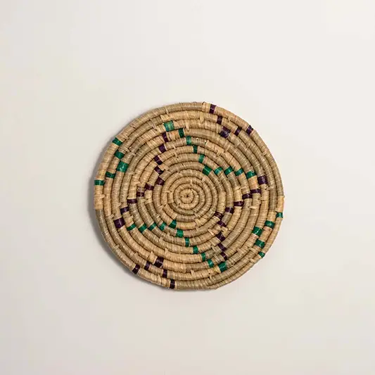 Green and natural woven decorative wall basket with geometric floral pattern for elegant wall styling and home decor.