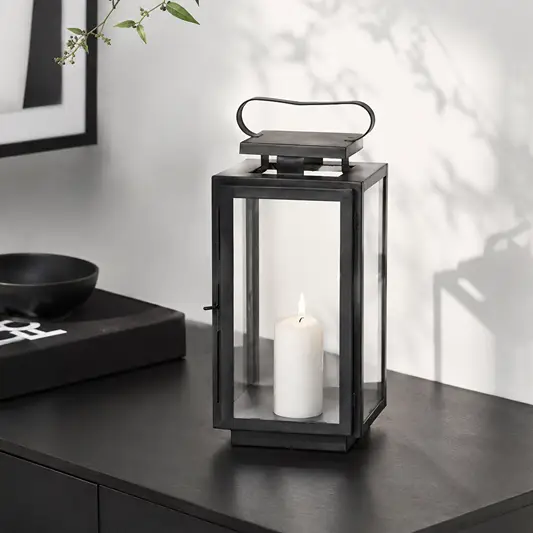 Lifestyle image of medium metal tower lantern for rustic patio decor styling and modern outdoor home patio lighting.