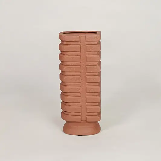 Terracotta ceramic decorative vase with geometric ribbed texture for modern tabletop and shelf decor placement.