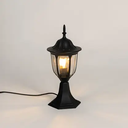 Vintage black outdoor gate light with warm glowing bulb for elegant exterior decor styling use.