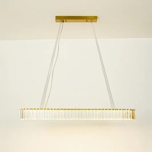 Minimal gold linear chandelier with slim design hanging against clean white ceiling background perfect for modern dining or kitchen lighting.