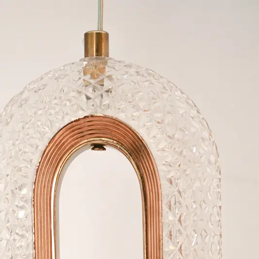 Detailed closeup of textured glass and rose gold metal oval led wall sconce pendant light fixture for modern home decor.