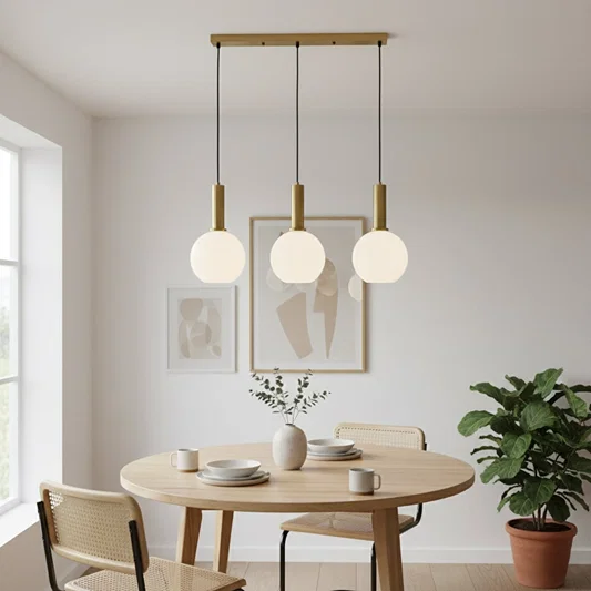 White glass and gold metal pendant lights adding elegance above the dining table in modern interiors.