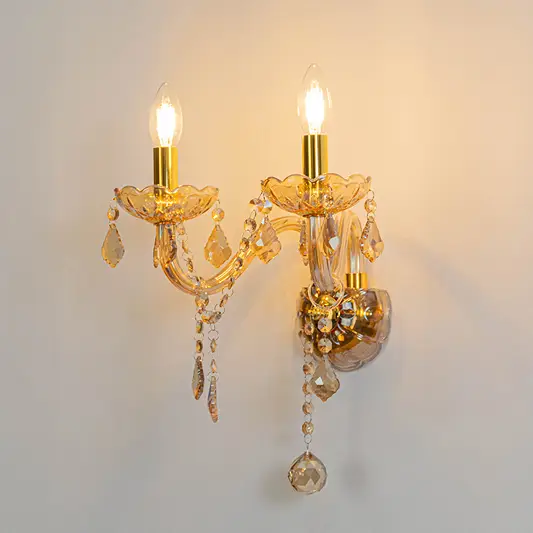 Classic crystal wall light in gold finish with candle bulbs and crystals for living room decor lighting white background.