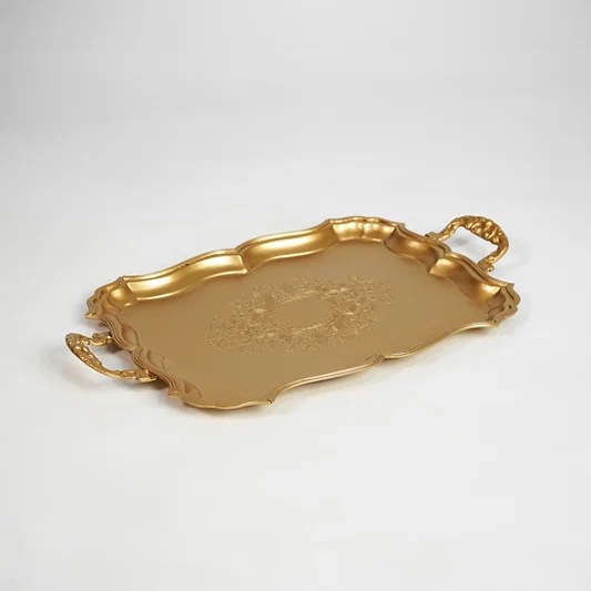 Gold metal serving tray with decorative handles for dining table coffee table on white background image.