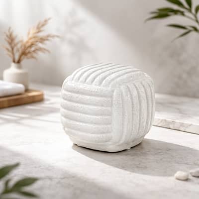 White ceramic textured decorative jar placed on coffee table creating soft and elegant home decor accent.