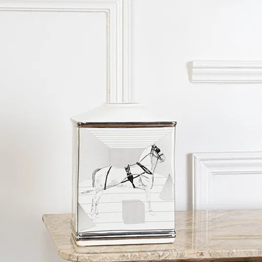 White ceramic jar with black galloping horse artwork in an angled view ideal for artistic décor and modern living room styling.