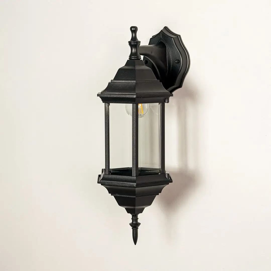 Black metal outdoor wall lantern with clear glass panels for modern exterior lighting decor placement styling.