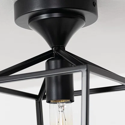 Closeup of black outdoor ceiling lantern highlighting the warm glowing bulb and clear glass cylinder designed for stylish exterior lighting.