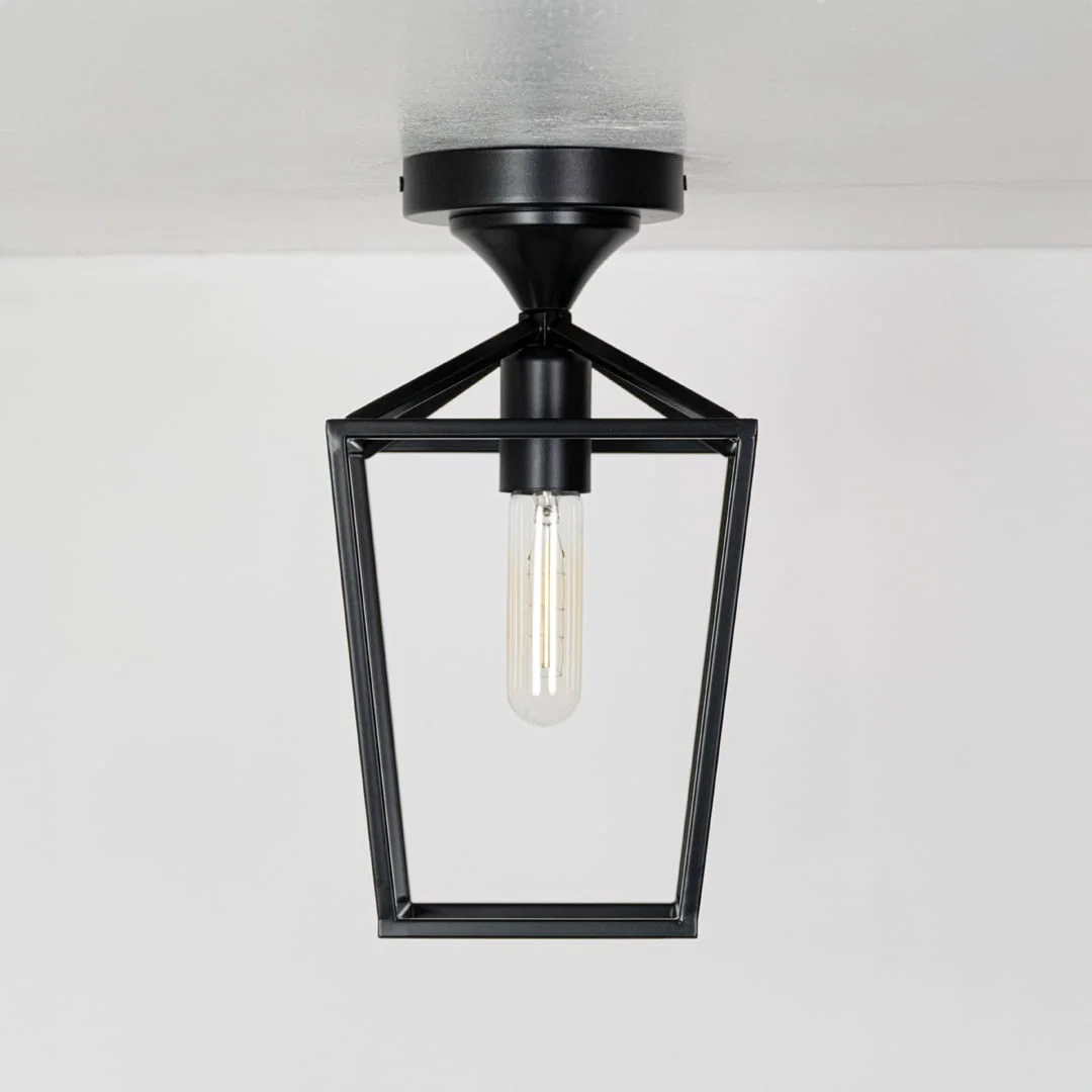 Outdoor black metal ceiling lantern with clear inner glass shown with lights off on a white background emphasizing its open frame design.