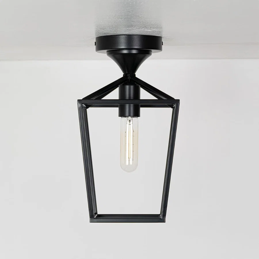 Outdoor black metal ceiling lantern with clear inner glass shown with lights off on a white background emphasizing its open frame design.