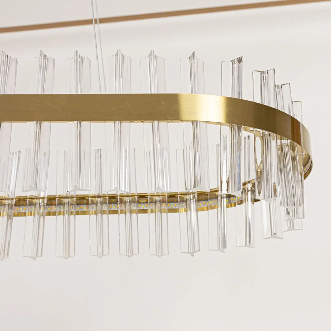 Closeup of gold metal chandelier highlighting the clear crystal rod detailing and elegant metallic frame crafted for luxurious modern lighting.