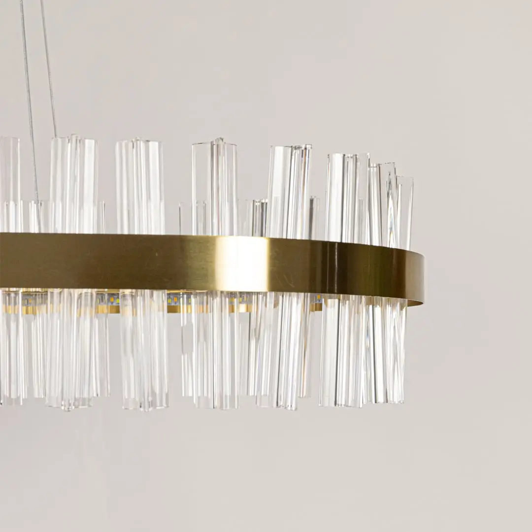 Closeup shot of gold metal chandelier focusing on its crystal textures and warm illumination for refined and elegant interior lighting.
