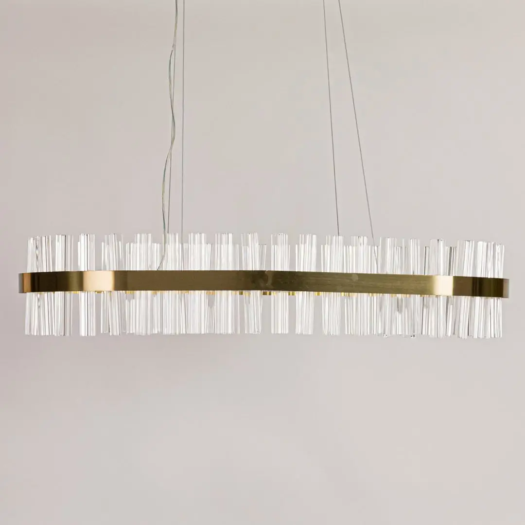 Gold metal chandelier with clear crystal rods displayed with lights off on a clean white background showcasing its sleek elongated shape.