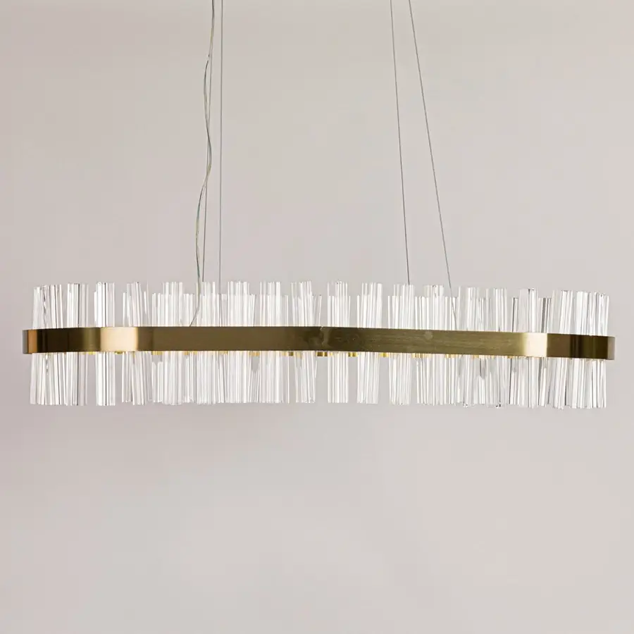 Gold metal chandelier with clear crystal rods displayed with lights off on a clean white background showcasing its sleek elongated shape.