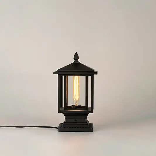 Black outdoor gate light with warm glowing bulb for modern exterior decor styling use.