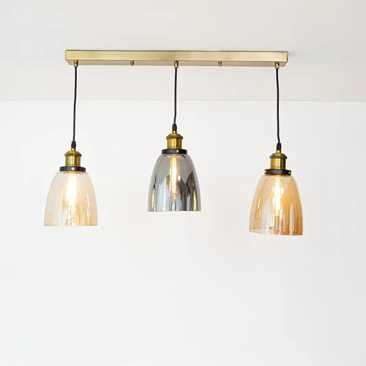 Amber smoke and clear glass pendant lights with gold accents for contemporary home decor spaces.