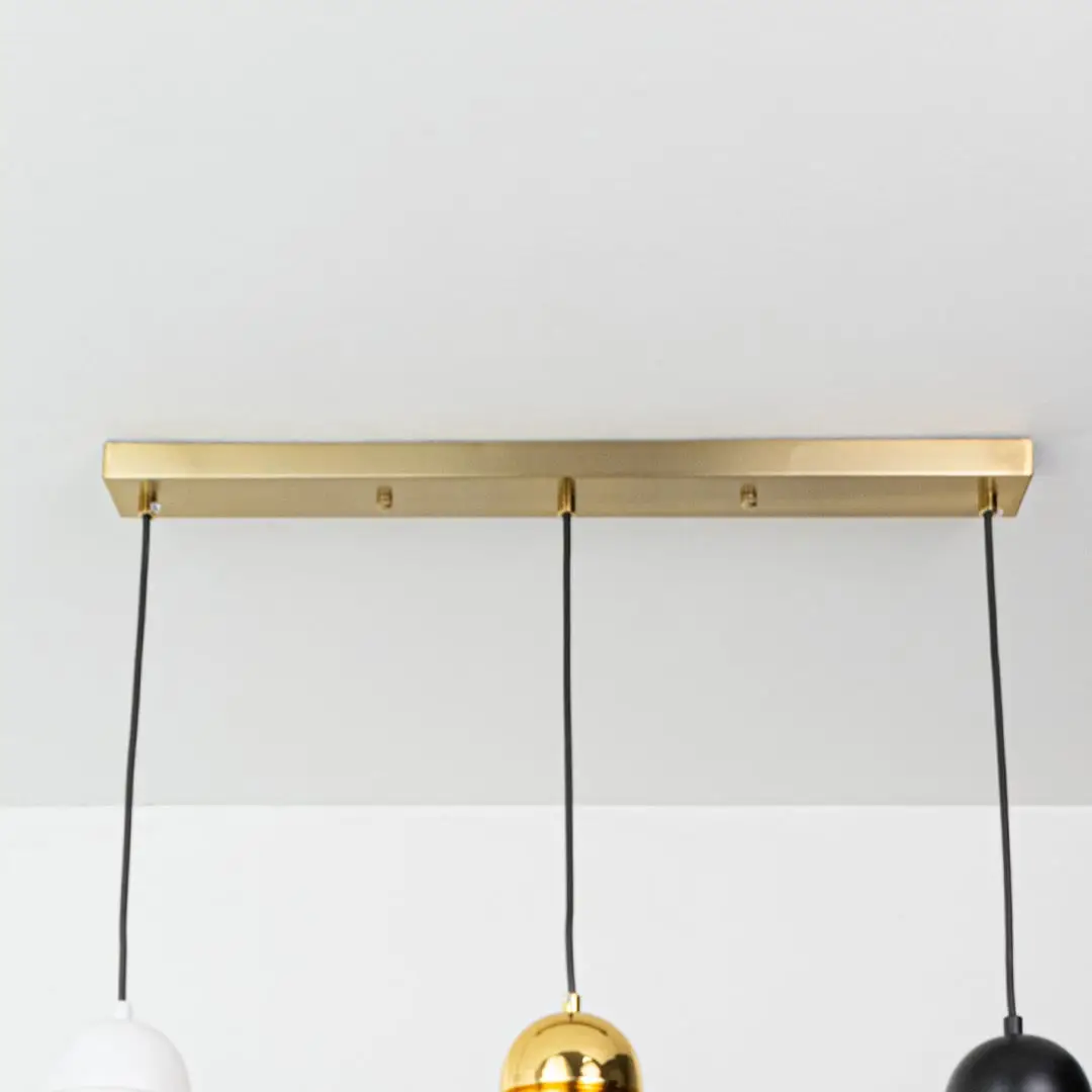 Gold metal linear canopy with suspended cords highlighting sleek modern craftsmanship and finish.