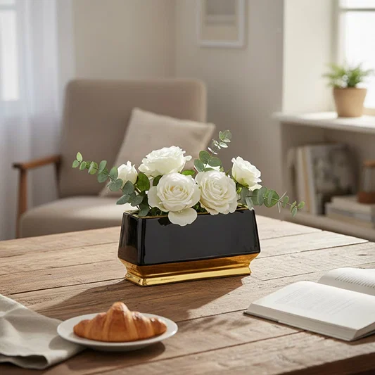 Black and gold metal planter styled on table in modern living room setting for elegant home decor display.