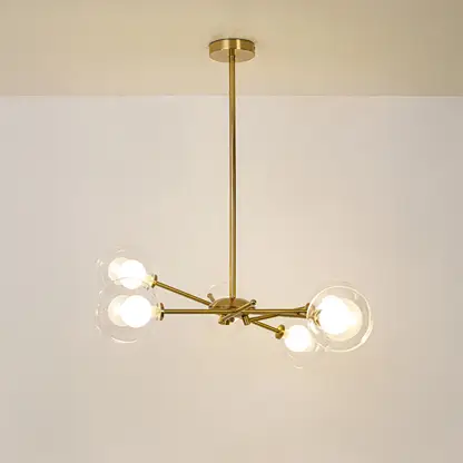 Gold metal chandelier with illuminated clear glass globe shades offering elegant contemporary ceiling lighting indoors.