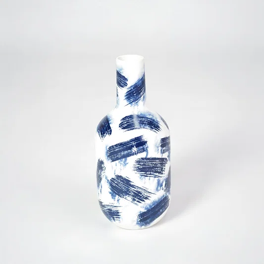 White ceramic vase with bold hand-painted blue brushstrokes for artistic home decor and modern interior style.