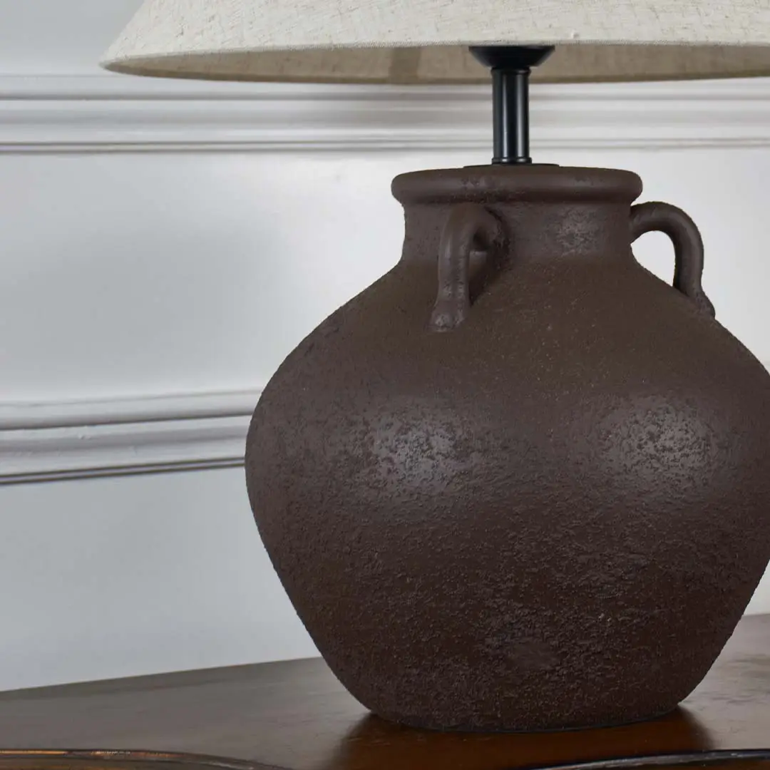 Brown textured ceramic table lamp base showcasing handcrafted detailing and rustic design for decorative interior lighting.