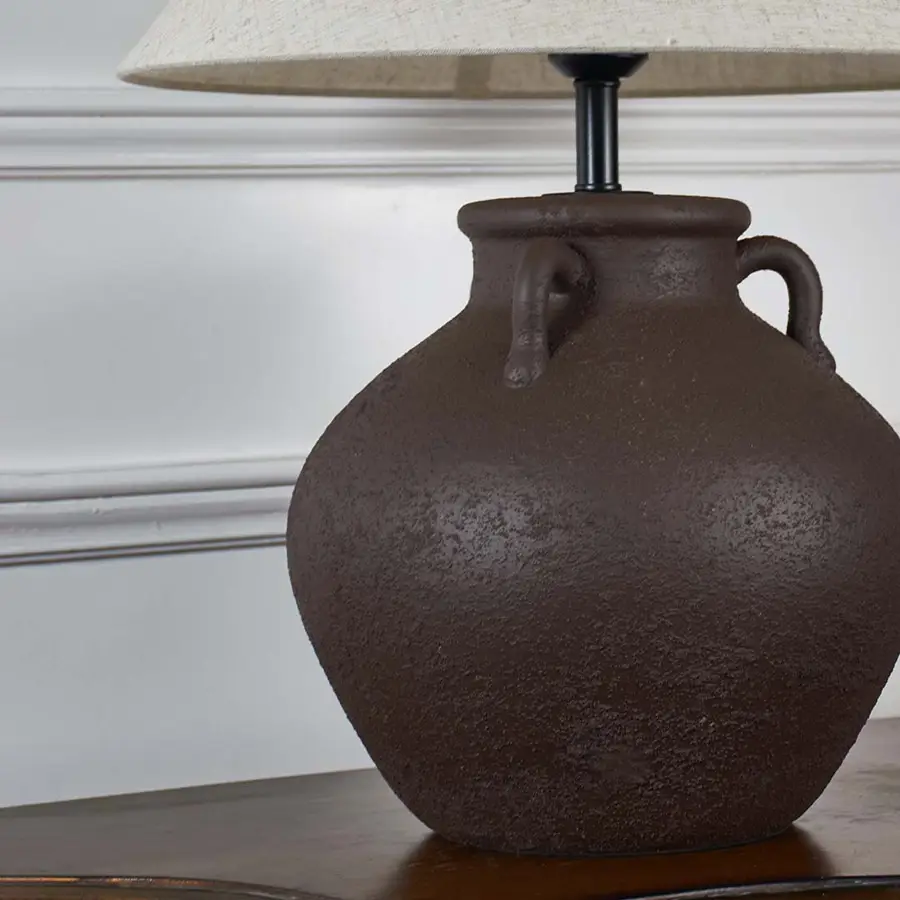Brown textured ceramic table lamp base showcasing handcrafted detailing and rustic design for decorative interior lighting.