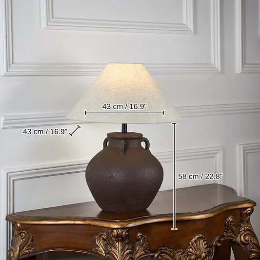 Brown ceramic table lamp with beige linen shade glowing, 58 x 43 x 43 cm (22.8 x 16.9 x 16.9 inches) dimensions