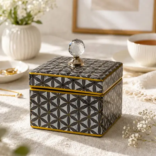 Black decorative storage box with gold geometric pattern styled on a coffee table for luxury modern home decor.