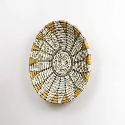 Natural handcrafted seagrass wall basket with white and mustard design for living room wall décor on white background.