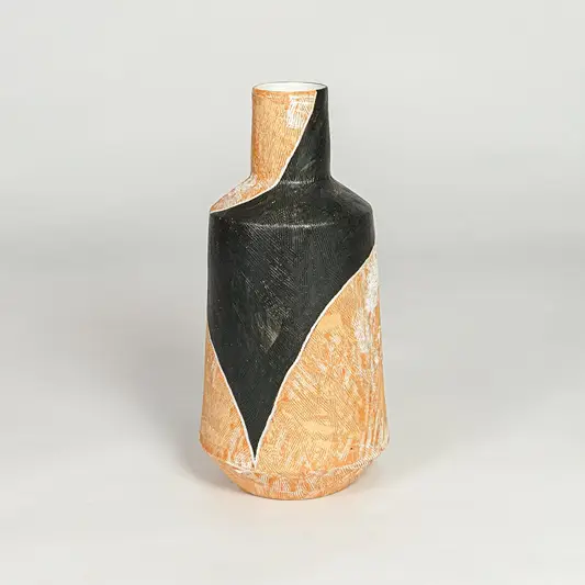 Modern orange and black ceramic statement vase with geometric sculpted body for shelf console or table styling.