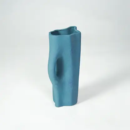 White background image of blue ceramic decorative vase for elegant shelf placement with textured matte finish.